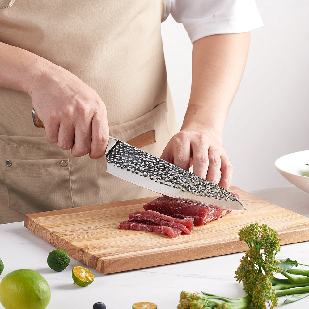 Professional chef precise cutting steak with japanese chef knife