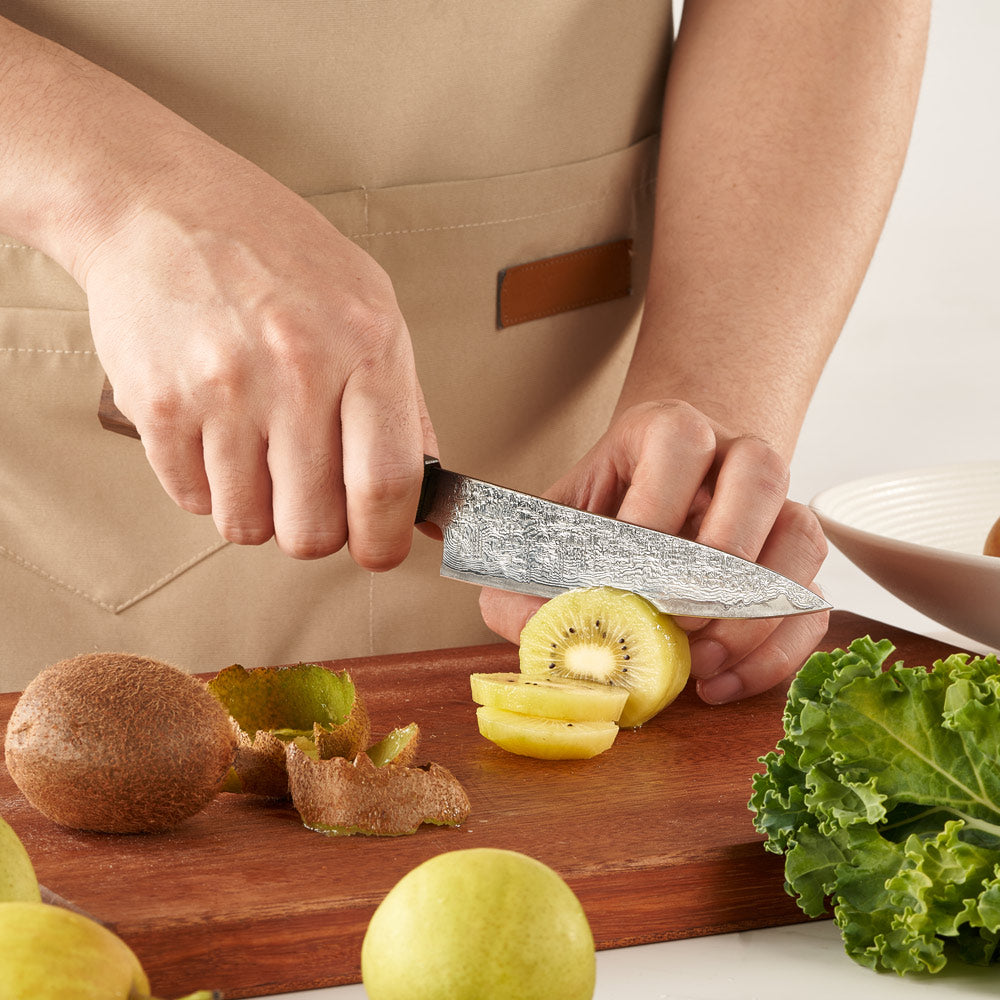Person cutting kiwis on a wooden board with a knife